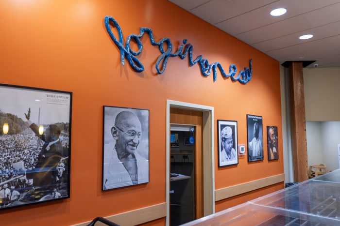 Orange wall and door to meeting space with “forgiveness” over the entry