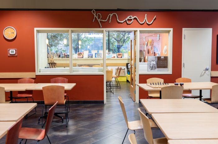 Empty tables in front of a large classroom or meeting space in a recovery support organization