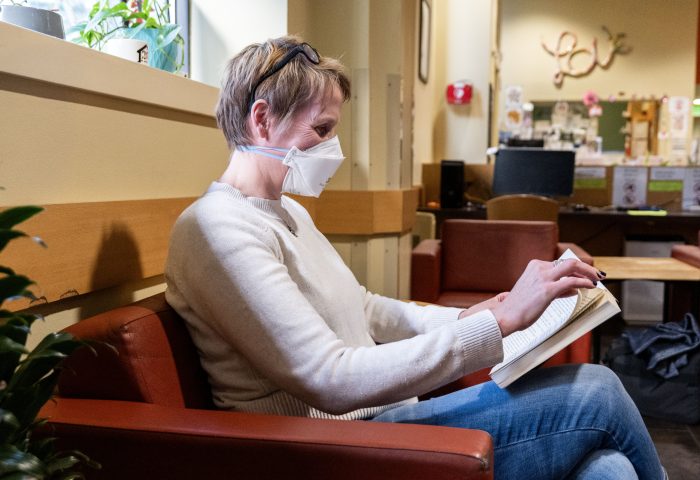 Recovery support organization visitor reads in a chair