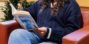 Recovery support organization visitor smiles as they read in a chair
