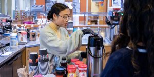 A barista at a recovery support organization cafe serves a visitor