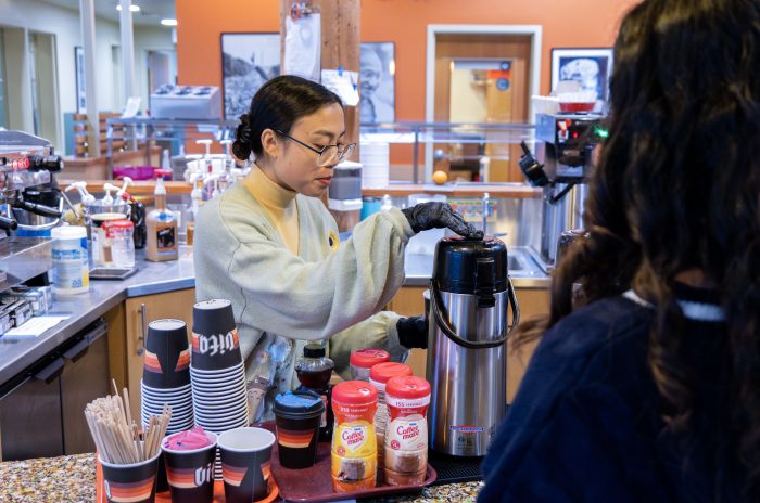 A barista at a recovery support organization cafe serves a visitor