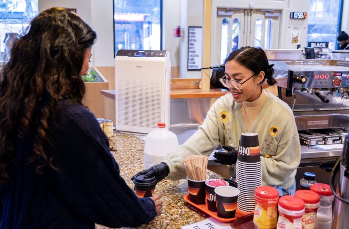 A barista in a recovery support organization cafe serves a visitor