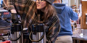 A barista in a recovery support organization cafe fills a cup with coffee